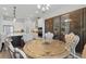 Elegant dining area with glass-door cabinets, an ornate table, and stylish chairs, and leading into kitchen at 16008 Volterra Pt, Montverde, FL 34756