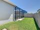 Green backyard with a full perimeter fence and partial view of screened in enclosure at 16084 Black Hickory Dr, Winter Garden, FL 34787