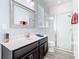 Well-lit bathroom featuring double sinks, a vanity with marble countertop, and a glass-enclosed shower at 16084 Black Hickory Dr, Winter Garden, FL 34787