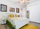 Bright bedroom features a white bed frame, floral bedding, wood-look floors, and cheerful decor at 16084 Black Hickory Dr, Winter Garden, FL 34787