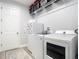 Laundry room with modern appliances and storage shelf at 16084 Black Hickory Dr, Winter Garden, FL 34787