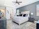 A stylish main bedroom features a large bed, tray ceiling with fan, and en suite bath at 16084 Black Hickory Dr, Winter Garden, FL 34787