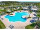 An aerial view of a large, inviting community pool surrounded by palm trees and lounge chairs at 16084 Black Hickory Dr, Winter Garden, FL 34787