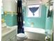 Retro bathroom with turquoise tile, a combined tub and shower, and vintage fixtures under a window at 1919 Waldo St, Orlando, FL 32806