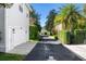 Long driveway leading to a house with white siding, attached garage, and well-manicured hedges at 2090 Common Way Rd, Orlando, FL 32814