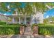 Charming home featuring a covered front porch, blue door, brick pathway and manicured landscaping at 2090 Common Way Rd, Orlando, FL 32814