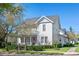 Charming two-story home with a covered front porch, lush landscaping, and inviting curb appeal on a sunny day at 2090 Common Way Rd, Orlando, FL 32814