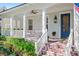 Inviting front porch features white pillars, a blue front door, and brick steps at 2090 Common Way Rd, Orlando, FL 32814