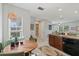 Bright kitchen and dining area with a modern light fixture, and tiled floors, ample cabinet space, and natural light at 2090 Common Way Rd, Orlando, FL 32814