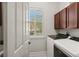 Laundry room with upper cabinets, modern washer and dryer, and a window for natural light at 2090 Common Way Rd, Orlando, FL 32814