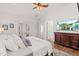 Bright main bedroom with white linens, wood floors, and ceiling fan at 2090 Common Way Rd, Orlando, FL 32814