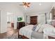 Bright main bedroom featuring wood floors, white linens, and a ceiling fan at 2090 Common Way Rd, Orlando, FL 32814