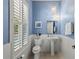 Charming powder room with stylish fixtures and blue walls at 2090 Common Way Rd, Orlando, FL 32814