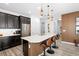 Beautiful kitchen featuring dark cabinetry, a large island, and modern pendant lighting above a bar seating area at 2145 Rush Bay Way, Orlando, FL 32824