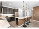 Well-lit kitchen with stainless steel appliances, a large island with bar stools, and modern pendant lighting at 2145 Rush Bay Way, Orlando, FL 32824