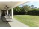 A covered patio area overlooks a spacious backyard with lush green grass and mature trees at 2351 Kelbrook Ct, Oviedo, FL 32765