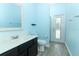 A refreshing bathroom with light blue walls, modern vanity, and a door leading to the outdoor area at 2351 Kelbrook Ct, Oviedo, FL 32765