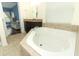 Elegant bathroom featuring a large soaking tub and dark wood vanity with granite countertop at 2351 Kelbrook Ct, Oviedo, FL 32765