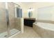 Modern bathroom boasts a glass shower, a soaking tub, and dark wood vanity at 2351 Kelbrook Ct, Oviedo, FL 32765