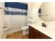 A bathroom featuring a vanity, toilet, cabinet and shower with blue accent curtain at 2351 Kelbrook Ct, Oviedo, FL 32765