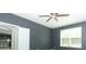 A serene bedroom featuring neutral gray walls, a modern ceiling fan, and natural light from the window at 2351 Kelbrook Ct, Oviedo, FL 32765