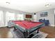 Spacious game room featuring a vibrant red pool table, a cozy seating area, and a functional bar area at 2351 Kelbrook Ct, Oviedo, FL 32765