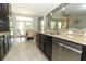 Modern kitchen featuring granite countertops, stainless steel appliances, dark cabinetry and an adjacent breakfast nook at 2351 Kelbrook Ct, Oviedo, FL 32765