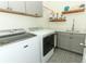 Well-organized laundry room with modern appliances, gray cabinets, stylish tile flooring, and decor at 2351 Kelbrook Ct, Oviedo, FL 32765