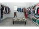 Organized walk-in closet with ample hanging space and patterned ottoman at 2351 Kelbrook Ct, Oviedo, FL 32765
