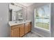 Bathroom featuring a double sink vanity, a large mirror with Hollywood lights, and a window with natural light at 275 Clydesdale Cir, Sanford, FL 32773