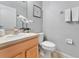 Well lit half bathroom features an oval sink on a light wood cabinet and neutral wall decor at 275 Clydesdale Cir, Sanford, FL 32773