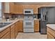 Neutral kitchen features wooden cabinets, light countertops, and stainless steel refrigerator and range at 275 Clydesdale Cir, Sanford, FL 32773