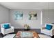 Living room featuring two light colored armchairs with turquoise pillows and Monopoly on the coffee table at 275 Clydesdale Cir, Sanford, FL 32773