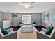 Living room with dark wood floors, gray walls, light armchairs with teal pillows, and bright natural light at 275 Clydesdale Cir, Sanford, FL 32773