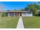 Charming single-story home with brick facade, walkway, and landscaped front yard under a clear, blue sky at 2805 Bongart Rd, Winter Park, FL 32792