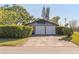 A two-car garage with a large driveway and mature landscaping in front of a light blue home at 2805 Bongart Rd, Winter Park, FL 32792