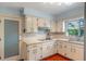 Cozy kitchen with white cabinets, tile backsplash, stainless steel sink, and natural light from the window at 2805 Bongart Rd, Winter Park, FL 32792