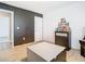 A modern bedroom features neutral paint, a dark accent wall and wood-look floors throughout at 2820 Black Birch Dr, Ocoee, FL 34761