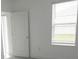 Bright bedroom features neutral walls, a window, and a door leading to an outdoor space at 2820 Black Birch Dr, Ocoee, FL 34761