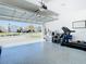 Spacious garage with epoxy flooring, offering ample storage and workout space; showcases neighborhood view when the door is open at 2820 Black Birch Dr, Ocoee, FL 34761