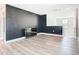 Bright living room features modern vinyl plank floors, neutral walls, a stylish dark accent wall, and staircase at 2820 Black Birch Dr, Ocoee, FL 34761