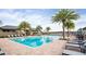 Community pool with lounge chairs and palm trees on a sunny day at 2820 Black Birch Dr, Ocoee, FL 34761