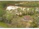 Aerial view of a property with a picturesque pond, surrounded by lush trees and greenery at 30041 Redoak Ave, Eustis, FL 32736