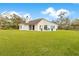 Spacious backyard featuring a well-manicured lawn and a charming white home with a cozy patio at 30041 Redoak Ave, Eustis, FL 32736