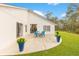 Bright back exterior showcasing a curved patio, sliding glass doors and a spacious manicured lawn at 30041 Redoak Ave, Eustis, FL 32736