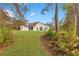 Wide shot of manicured backyard featuring a white home and a lush landscape at 30041 Redoak Ave, Eustis, FL 32736