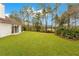 Manicured backyard with ample green space and views of a tranquil pond and surrounding lush trees at 30041 Redoak Ave, Eustis, FL 32736