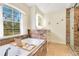 Bright bathroom features a soaking tub with a view, vanity, and tiled shower at 30041 Redoak Ave, Eustis, FL 32736