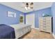 Cozy bedroom with a ceiling fan, closet, tile floors, and bright blue walls at 30041 Redoak Ave, Eustis, FL 32736