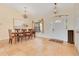 Sunlit dining room with elegant chandeliers, tile floors, and a view of the front entry at 30041 Redoak Ave, Eustis, FL 32736